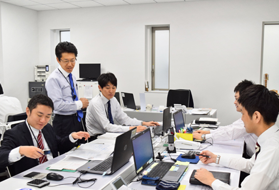 ミーティングで情報共有する東京都民銀行医療・福祉事業部の行員と上原敦部長（左から2人目、12月6日、本店）＜ニッキン12月8日号7面＞