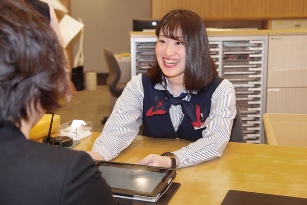 タブレット端末で商品を案内する、個人営業の担当者(2019年12月16日、山陰合同銀行本店)