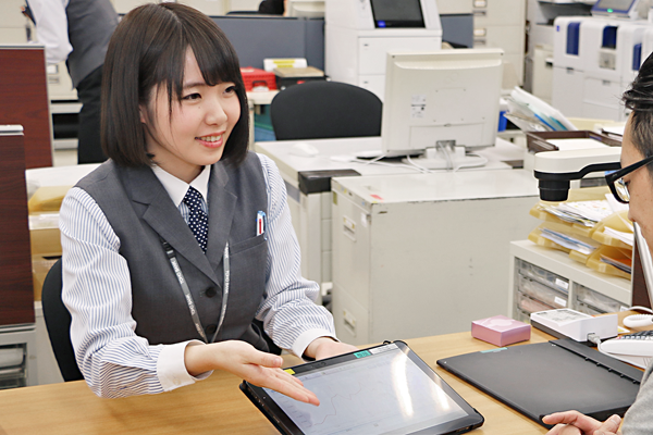 タブレット端末を用いて来店客に商品説明をする、東邦銀行本店営業部のマネープランナー(１月28日、東邦銀行本店)