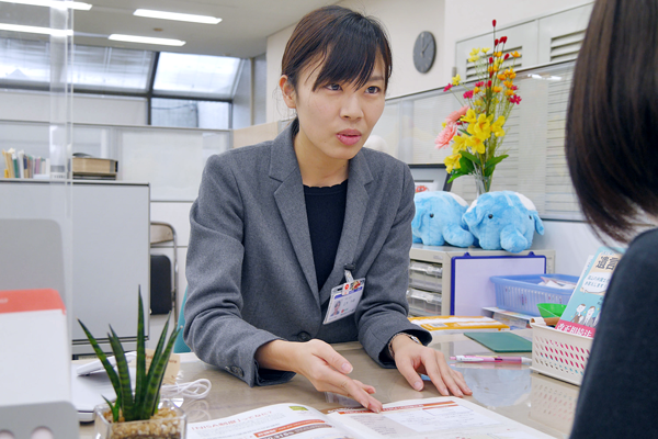 窓口でニーズ発掘に努めるファイナンシャルアドバイザー担当者(２月17日、トマト銀行本店営業部で)