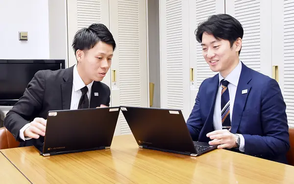本店営業部取引先の職域セミナーについて相談する法人担当者と個人担当者（右、３月13日、鳥取銀行本店）
