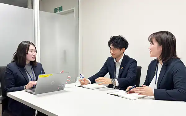 本店営業部に臨店し、新入行員2人から預かり資産に関する研修や勉強会の改善点などを聞き取る営業企画部の遠藤里菜さん（左、1月14日、山形銀本部）