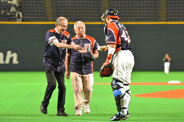 始球式ピッチャーの藤井敬一・大丸社長(中)とファイターズの黒羽根利規捕手からボールを受け取る石井頭取(左、札幌ドーム)。