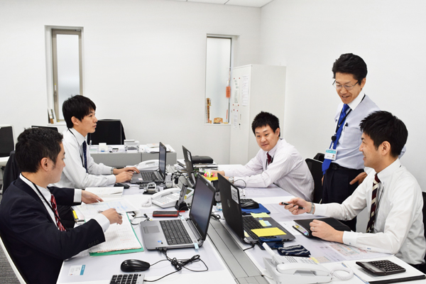 ミーティングで情報共有する医療・福祉事業部の行員と上原部長。(左から４人目、12月６日、東京都民銀行本店)