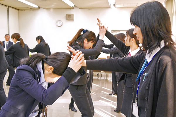 女性警官(左)から髪をつかまれた際の離脱方法を学んだ。(２月６日、本店)