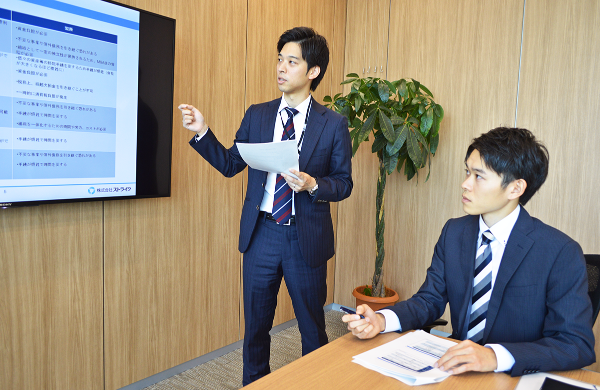 ストライクの森貞暁シニアアドバイザー(左)から講義を受ける高田支店の千葉勇輝さん(10月18日、ストライク)
