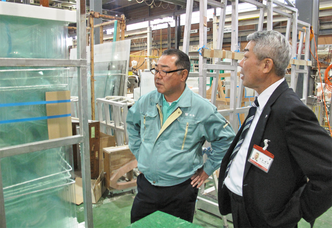 新光硝子工業の新海社長(左)と同社工場を視察する王生幸夫支店長(10月29日)