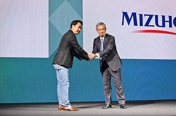 新銀行設立に向け握手を交わす出澤・LINE社長(左)と岡部・みずほFG副社長(11月27日)