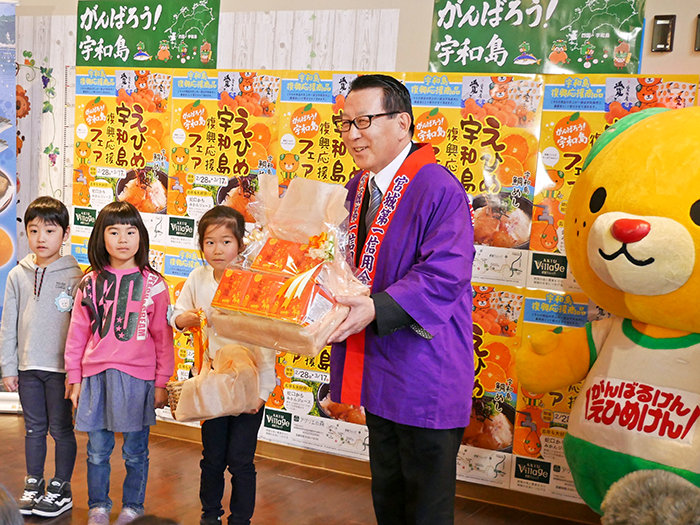 保育園児に宇和島特産ブラッドオレンジ使用の「どら焼き」を贈る宮城第一信金の菅原理事長(2月28日、仙台市内の観光施設「秋保ヴィレッジ」)