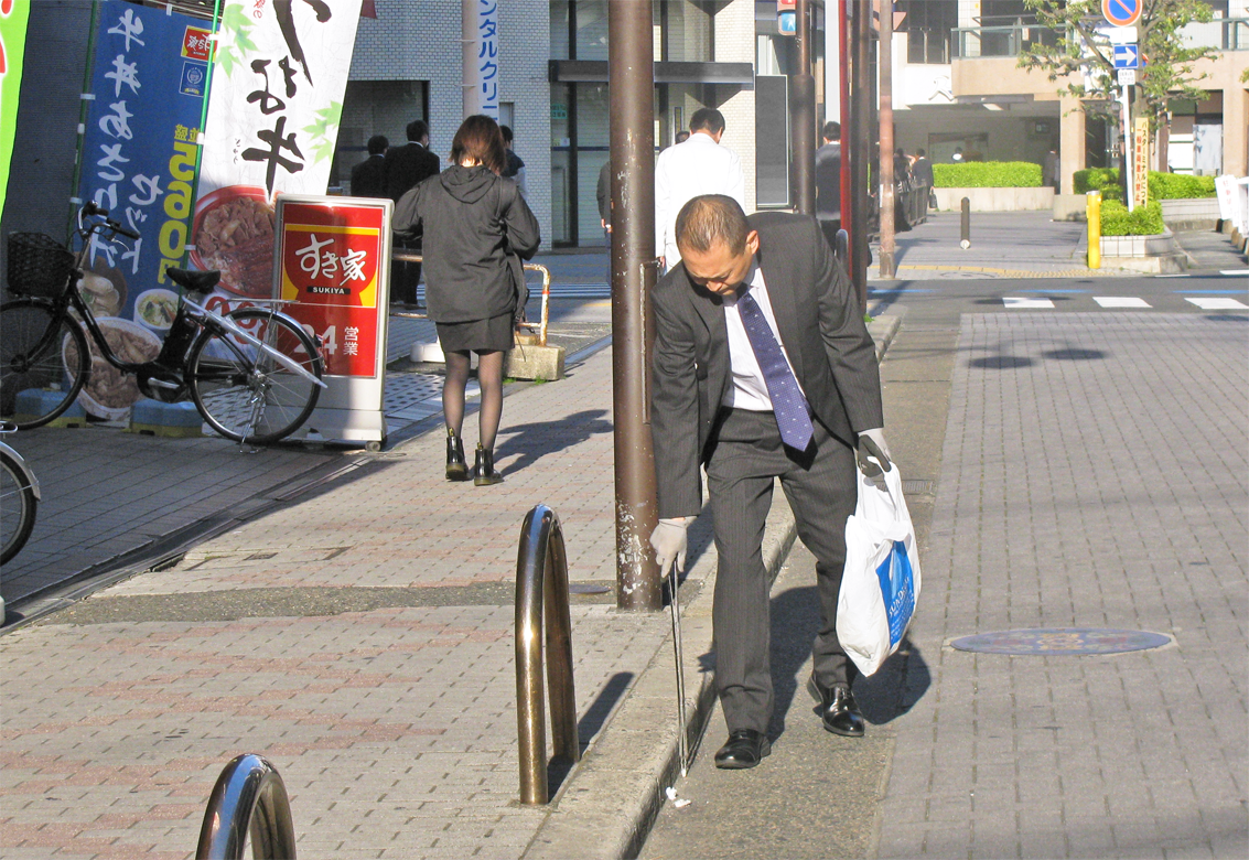 毎朝６時45分から約30分、近くの商店街や店舗周辺を清掃する今田好宣支店長（４月18日）