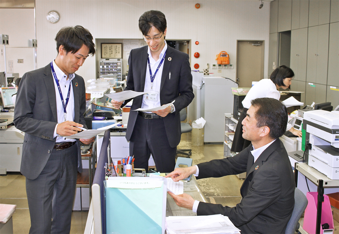 店内で法人営業担当者2人とミドルリスク先の取引方針策定ミーティングを行う中広学支店長(右、5月16日)