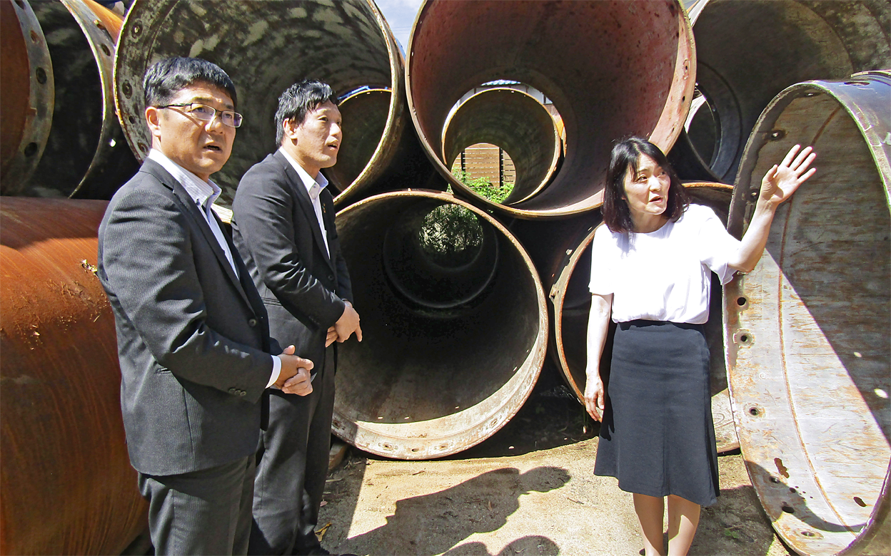 建設工事機材を取り扱う小金丸工業の小金丸潤子社長(右)から説明を聞く村竹学支店長(左)と畑正比古営業課長(5月22日)