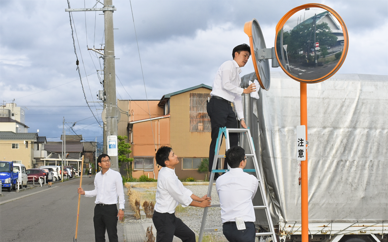 地域のカーブミラーを清掃する三条信用金庫