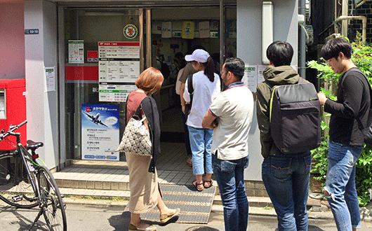 外国人の多い地域では、ＡＴＭに並ぶ顧客の大半が外国人という場面も（６月、東京都内）