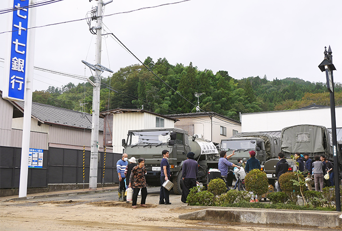 七十七銀丸森支店の駐車場では、自衛隊による近隣住民向けの給水作業が行われた(10月14日、宮城県丸森町)