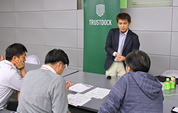 銀行の担当者にe‐KYCサービスを説明するトラストドックの千葉孝浩CEO(中央、10月18日、第二地銀協)