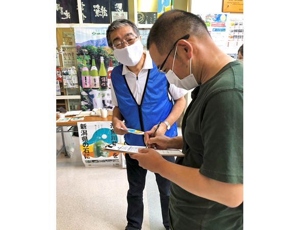 署名を呼び掛ける黒石孝・糸魚川信組理事長(左、9月5日、フォッサマグナミュージアム)