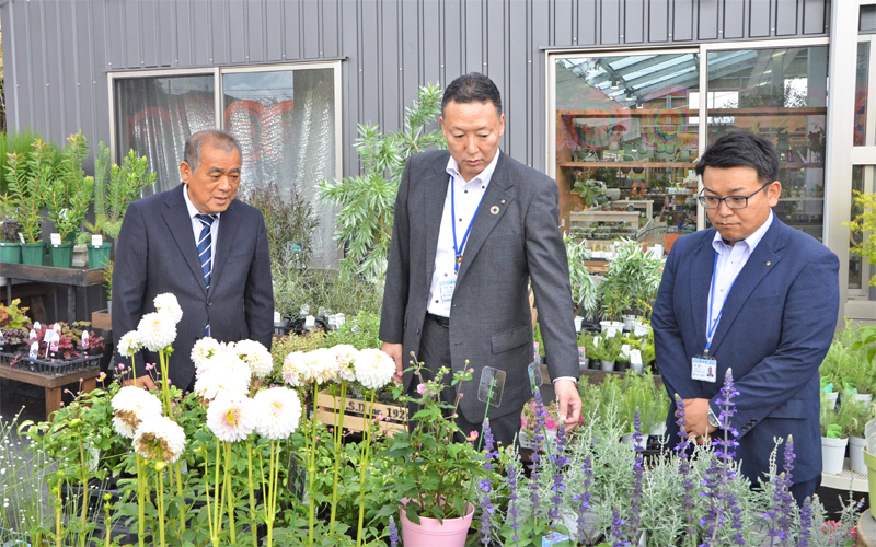 農園芸資材などを販売する大正堂の吉成仁会長（左）に園芸植物の説明を受ける半田雅一支店長（中央）と森諭史支店長代理（９月15日）＜写真撮影時にマスクを外していただきました＞