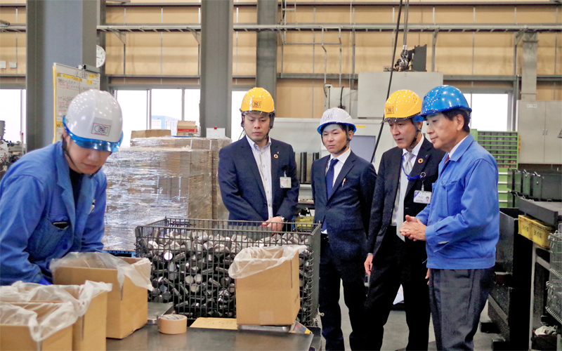 小川哲洋社長(右)から工場内で説明を受ける伊藤隆行支店長(右から2人目)と清水貴文係長(同4人目)(11月20日)<写真撮影時にマスクを外していただきました>