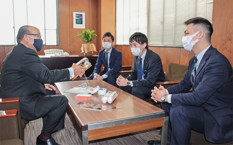 ラベルや粘着資材の製造・販売を行う大共の岡崎正彦社長(左)から商品説明を受ける(左から3人目)大正銀行出身の担当者、徳島銀行出身の高橋一記主任(右、1月27日、東大阪市)