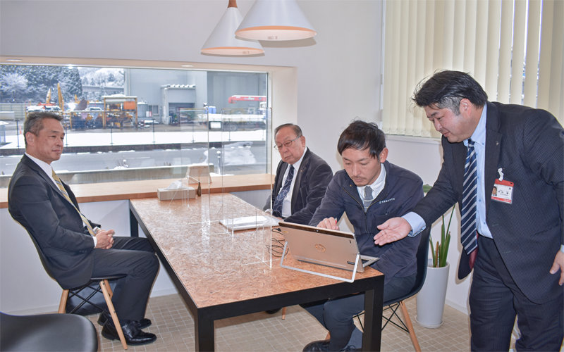 マツバラの松原靖之社長(左から2人目)と松原大輔専務(同3人目)に預かり物件管理システムで私募債書類の受け渡しを確認する中川博得意先課長(右)と東田裕一郎支店長(2月8日、金沢市内)<写真撮影時にマスクを外していただきました>