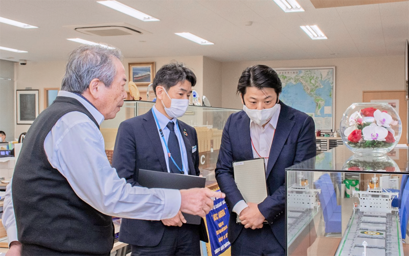 洞雲汽船の大河内源二社長(左)から船舶の説明を受けるなど日頃から船主とのリレーションを重視する佐藤浩一・伊予銀行シップファイナンス部次長(中央)と中村友則・波止浜支店担当課長(2月2日、今治市内の洞雲汽船)