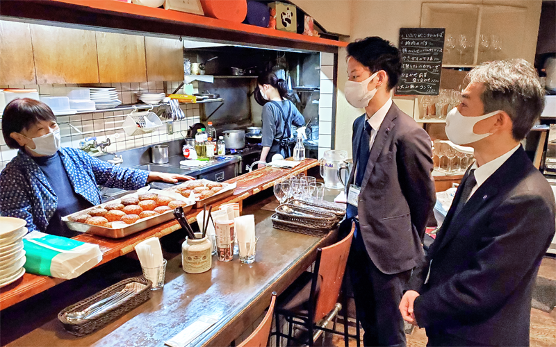 新規融資先の洋食屋「ビストロ周」のオーナー宮嶋順子さん(左)に経営状況を聞く東京シティ信金日本橋支店の道下克徳支店長(右)と得意先係の吉江司氏(3月3日、東京都中央区)