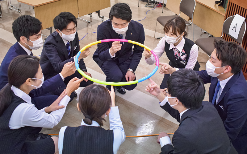 ゲーム型ワーク「ヘリウムリング」に挑戦した熊本第一信金の新入職員(4月12日、熊本第一信金本店)