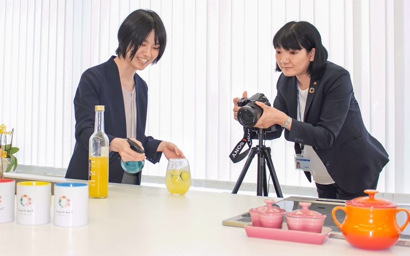出店者の商品を紹介する写真を撮影する阿波銀行コネクト社員(6月17日、徳島市)