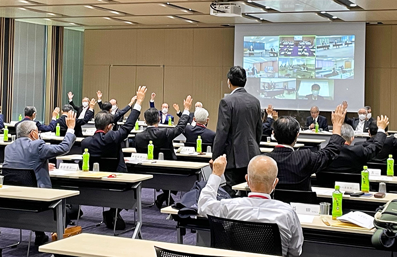 ウェブ会議システムでつないだ地区会場ごとに議案の賛否を挙手で確認した(6月29日、全国信用組合会館)