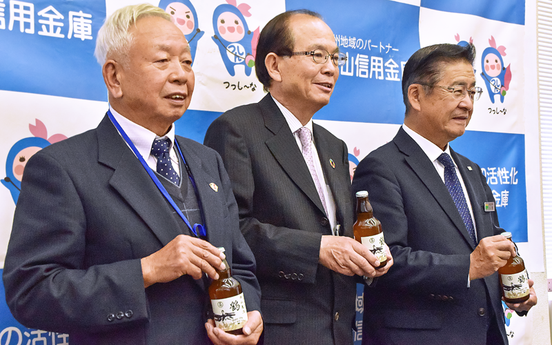 津山発のビールをアピールする松岡裕司理事長(中央)ら関係者(11月30日、津山信用金庫本店4階会議室)