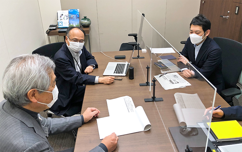 三井住友信託銀のTBFチームで水素や燃料電池を専門とする羽田貴英主任調査役(右奥)らを交えてミーティングする後藤主管(左奥、2月14日、本店)