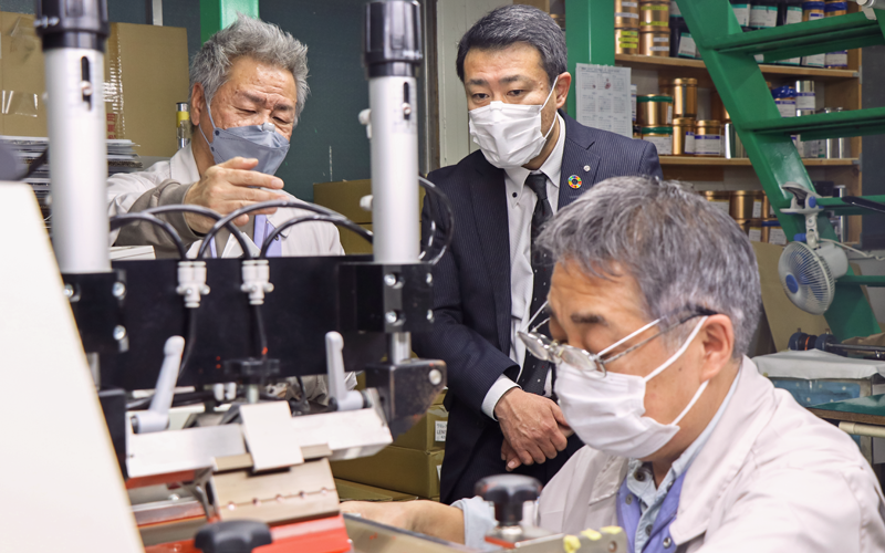河合保弘・ヒロテック社長(左)の案内で工場を見学する塚越貴浩支店長(1月26日、ヒロテック)