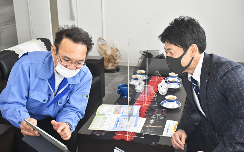 クラタニの倉谷純弘社長(左)と情報交換をする水野伸之助支店長(3月18日、射水市)