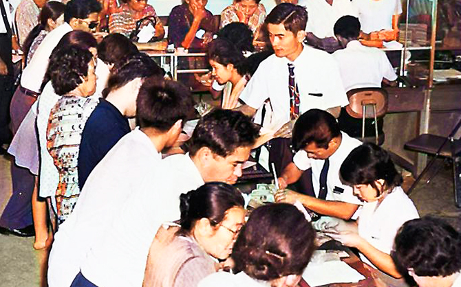 変動相場下でドル資産の目減りを防ぐ確認で、混雑する沖縄銀行栄町支店（1971年10月８日、沖縄銀行提供）
