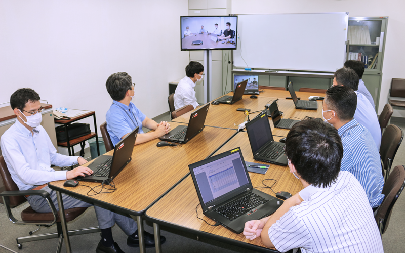 和キャピタルの役員(中央奥)とオンラインで月次ミーティングを行う山梨中央銀行市場国際部の担当者(7月19日、山梨中央銀行本店)