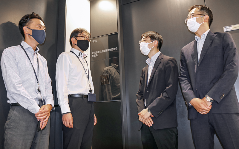 東京都中小企業活性化協議会の担当者と案件の進ちょくについて情報交換するきらぼし銀行融資管理部の行員(右側2人、8月30日、丸の内二重橋ビル)