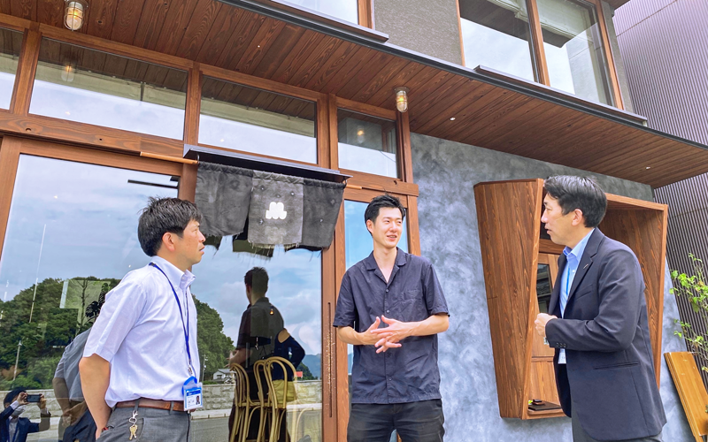 「アズミ瀬戸田」を誘致したStapleの岡雄大代表取締役(中央)と話す竹谷広樹・広島銀行瀬戸田支店長(右、提供)
