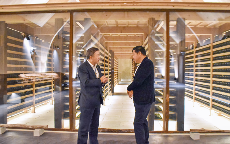 「エシコト」内のスパークリング日本酒の二次発酵室の前で情報を交換する北坂竜平支店長（左）と水野直人社長（11月18日）