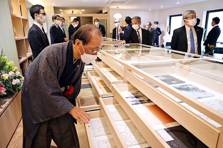 マップケース内の素材をながめる門川大作・京都市長(12月9日、京都アンプリチュード展示場2階)