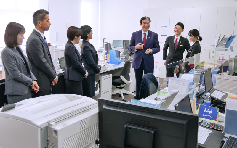 高崎問屋町に移転開店した「群馬銀行 個人相談プラザ高崎」で行員を激励する深井彰彦頭取（左から５人目、2022年12月８日）