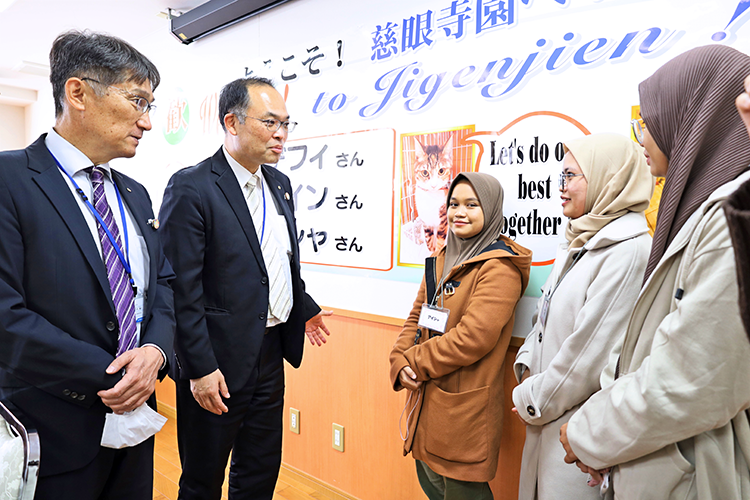 インドネシアから来日した3人と話す鹿児島相互信金の小川陽三理事・地域支援統括副本部長(左から2人目、2月1日、特別養護老人ホーム「慈眼寺園」)