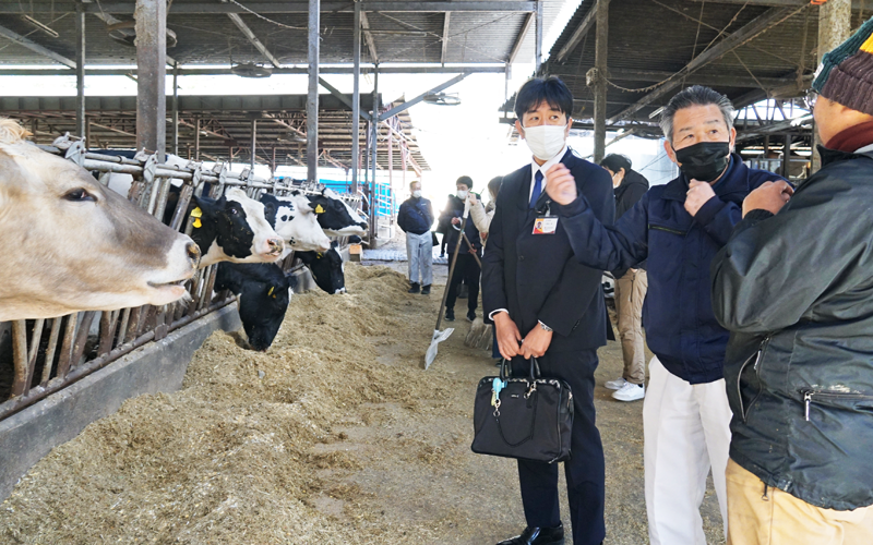 ホエイの原料となる牛乳を生産する酪農業者の現状を聞く小野田明支店長（右から３番目、２月21日、ちちぶ路吉田牧場）