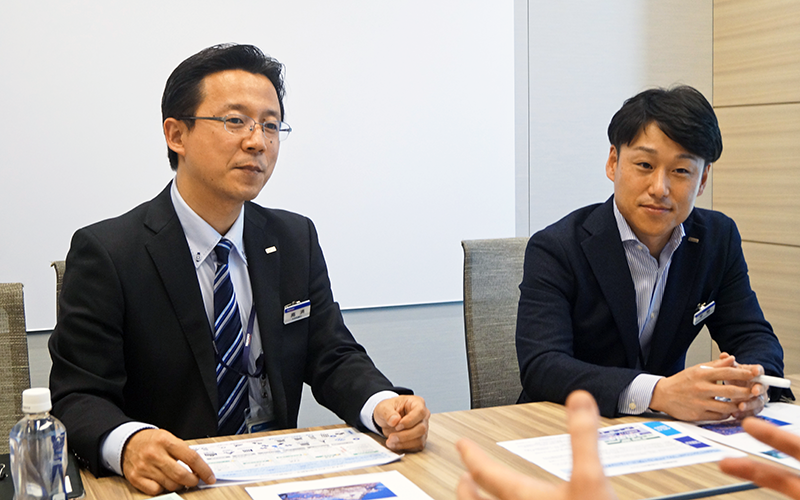 グループ会社の行員と地域活性化案について協議する地域創生デスクの高済デスク長(左)と平野達也参事役(4月13日、本店)