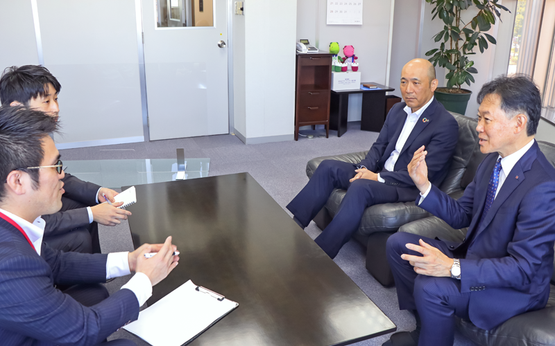 井上繁社長(右手前)と進ちょく中の案件について話すコンサルティング営業部と福井支店の行員。右奥は手下康和執行役員支店長(5月11日、井上商事)