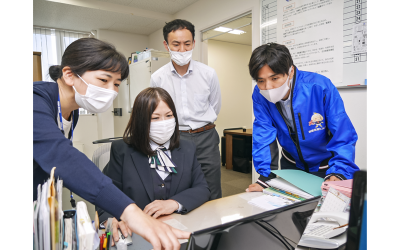 徳島空港ビルの兵庫春代総務部次長（左から２人目）らにクラウドシステムの操作方法を教える阿波銀コンサルの担当者（左、５月23日、徳島空港ビル）