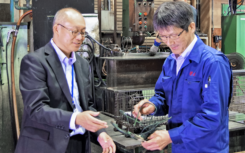 清信熱処理工場で、石田幸雄代表取締役（右）から事業について聞く相澤英紀支店長（６月20日、清信熱処理工場）