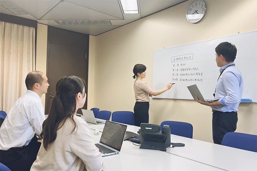 法務部のメンバーと勉強会を開催する社内弁護士（左奥、野村HD提供）