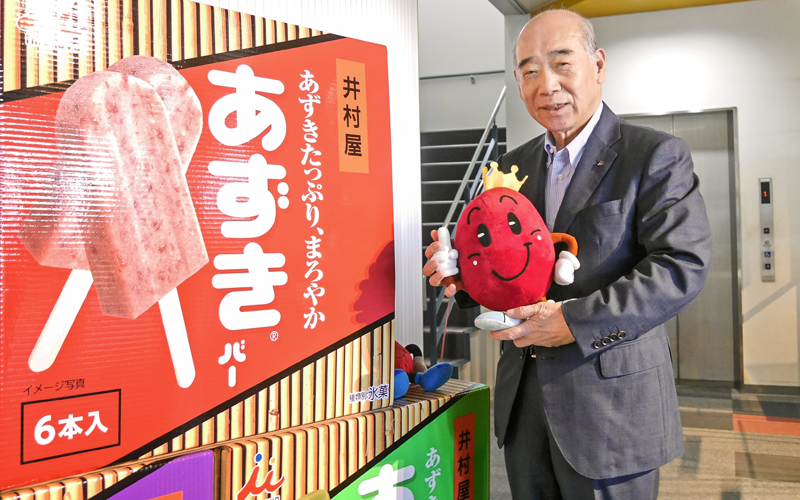マスコットキャラクターのアズキキングと主原料のあずきをアピールする浅田剛夫氏(井村屋グループ本社)
