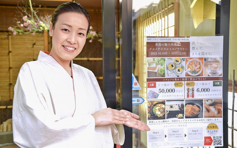 ポスターを紹介する「割烹大善」の女将・大坂美佳子さん（10月16日、新潟市）